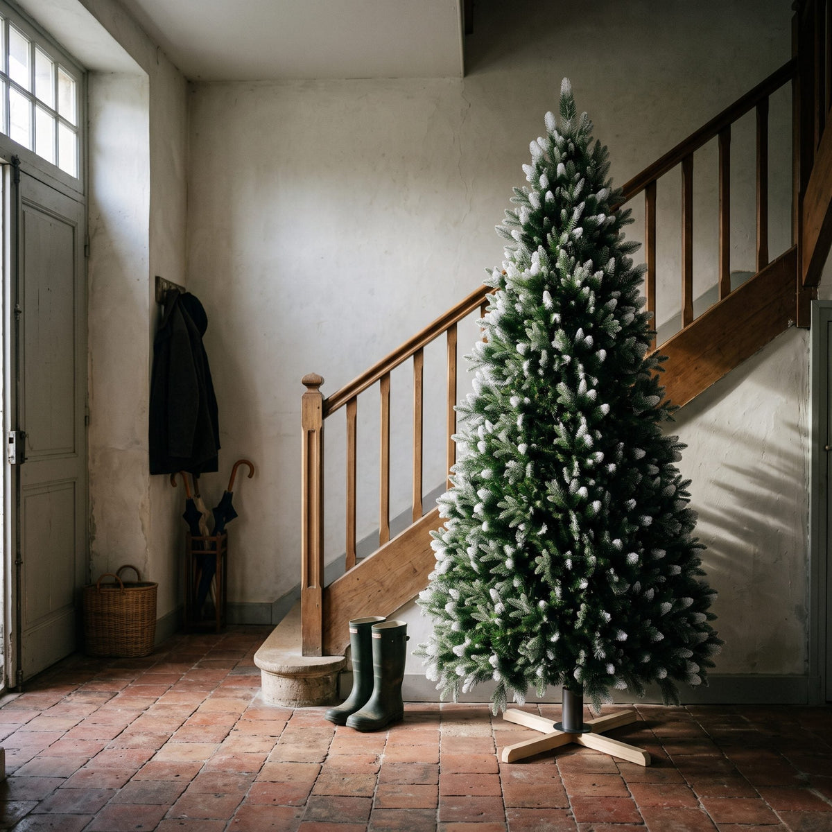 Grand sapin artificiel enneigé de 225 cm dans une cage d'escalier Image